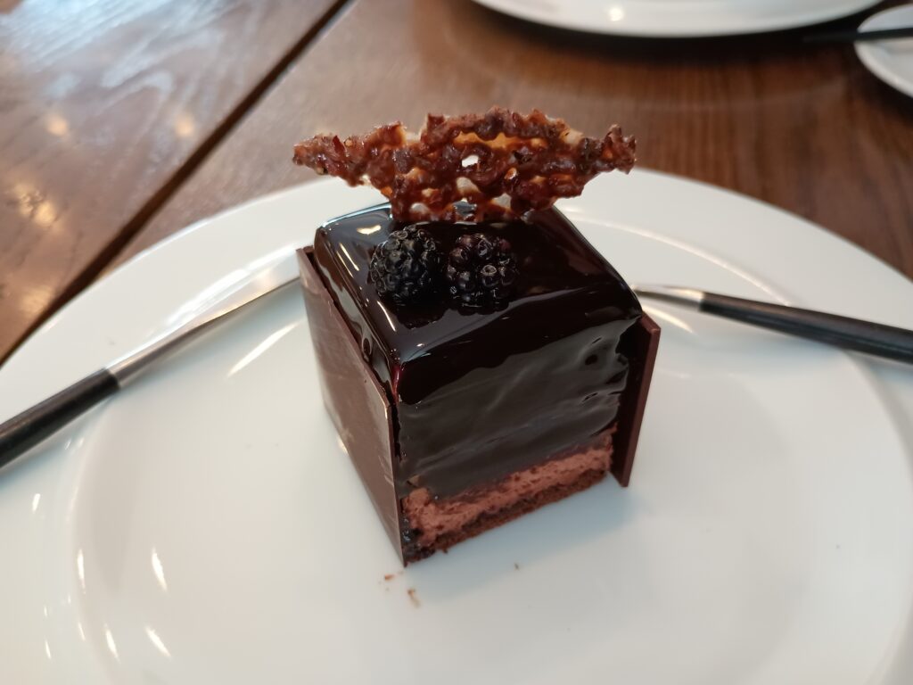 「ル・シュープレーム」の断面。ツヤのあるチョコレートコーティングの下に、ふわっとしたチョコレートムースの層。ブラックベリーの果実が見え、複層構造になっている