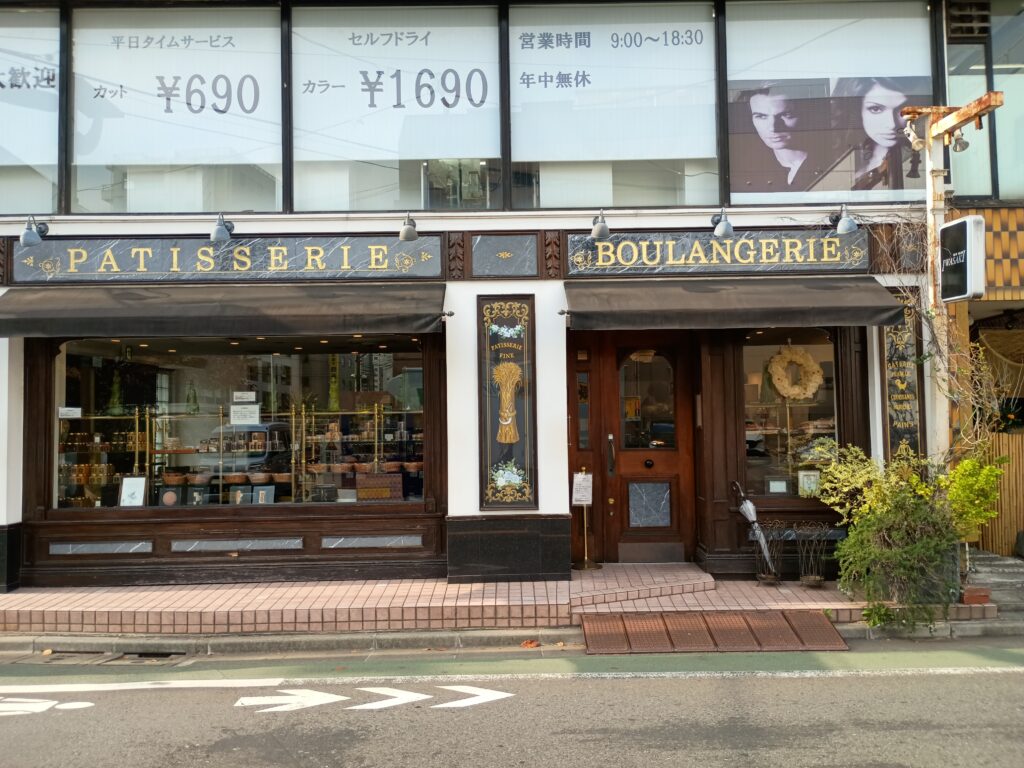 パリセヴェイユの店舗外観。白い壁にフランス語の看板、入口前に行列ができている。路地裏のパリのケーキ屋さんを思わせる、飾らない佇まい