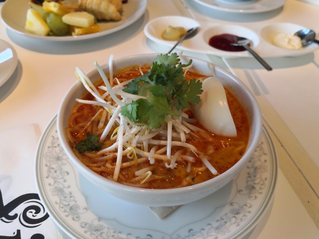 （ラクサ）
シンガポールラクサヌードル。赤いココナッツスープに麺、もやし、パクチー、すり身団子がのる